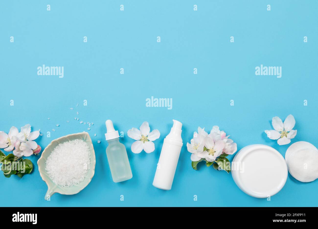 Sauber reinen Frühling Beauty-Produkte Hintergrund. Weiße Objekte feuchtigkeitsspendende Cremes, Pipettenölflasche, Badesalz in der Schüssel. Flacher blauer Hintergrund, whi Stockfoto