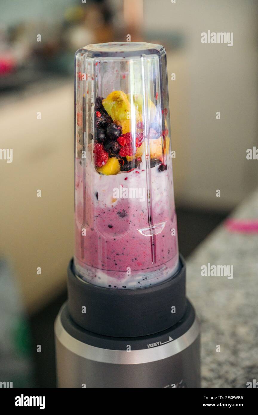 Smoothie-Schüssel mit Mango und Beeren im Mixer Stockfoto