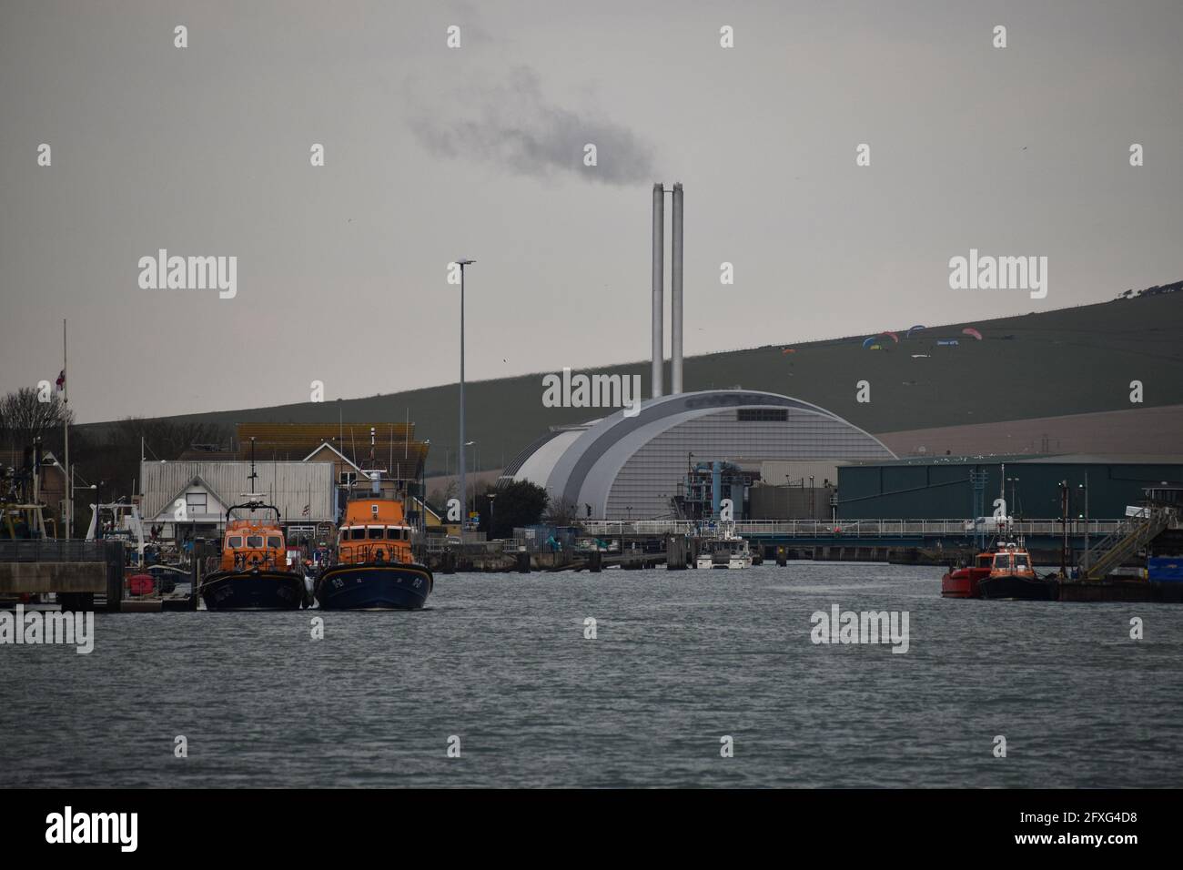 Zwei RNLI-Rettungsboote sitzen am Newhaven RNLI mit der Nachverbrennungsanlage von Newhaven Steht über ihnen Stockfoto