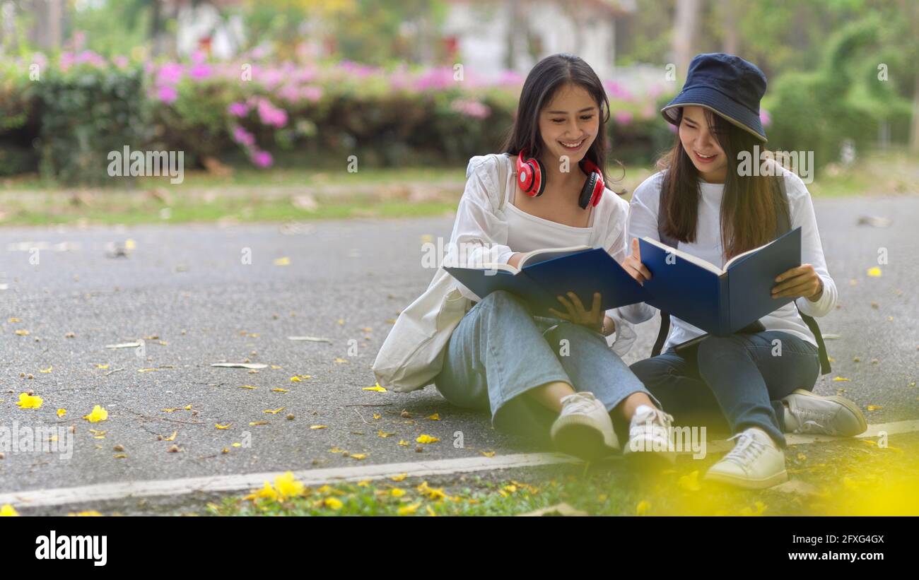 Eine kurze Aufnahme von zwei jungen, hübschen Studentinnen, die im Freien studieren Gemeinsam auf dem Campus Stockfoto