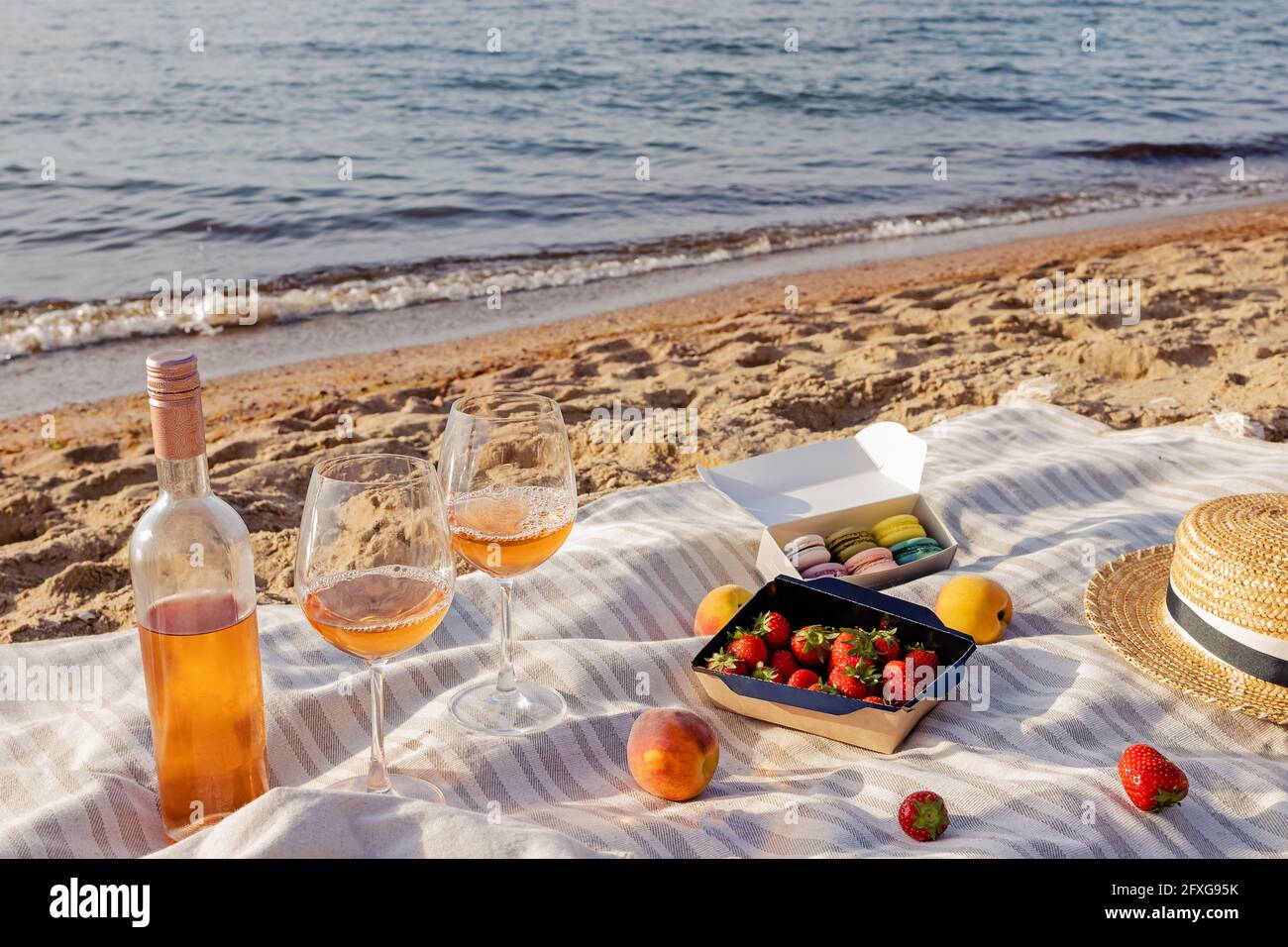 Rosenwein, Pfirsiche und Erdbeeren am Strand. Stockfoto