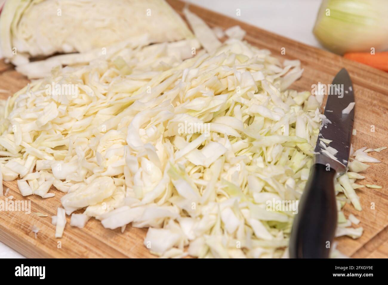 Gehackter Kohl und Messer auf Holzschneidebrett in der Küche Stockfoto
