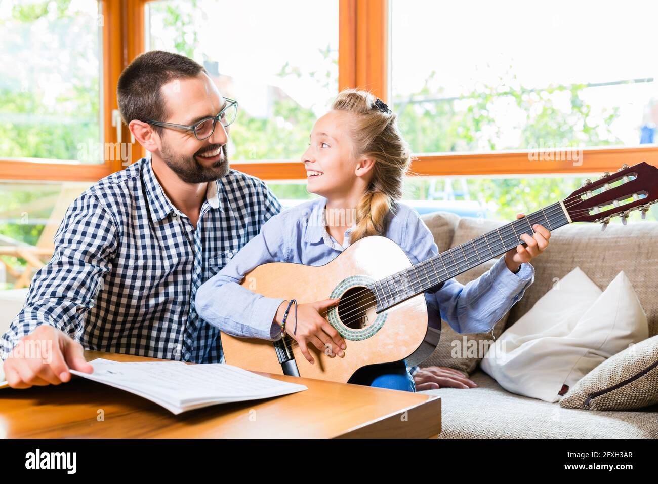 Vater und Tochter lernen Gitarre spielen, Musik zusammen machen Stockfoto