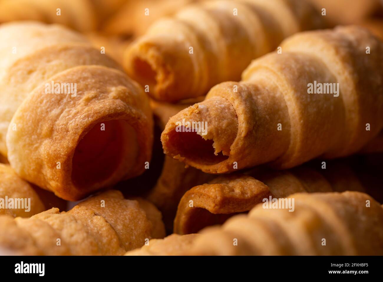 Viele süße hausgemachte Süßwarenröhrchen, die mit Creme gefüllt werden können. Foto aufgenommen unter weichem Kunstlicht. Stockfoto