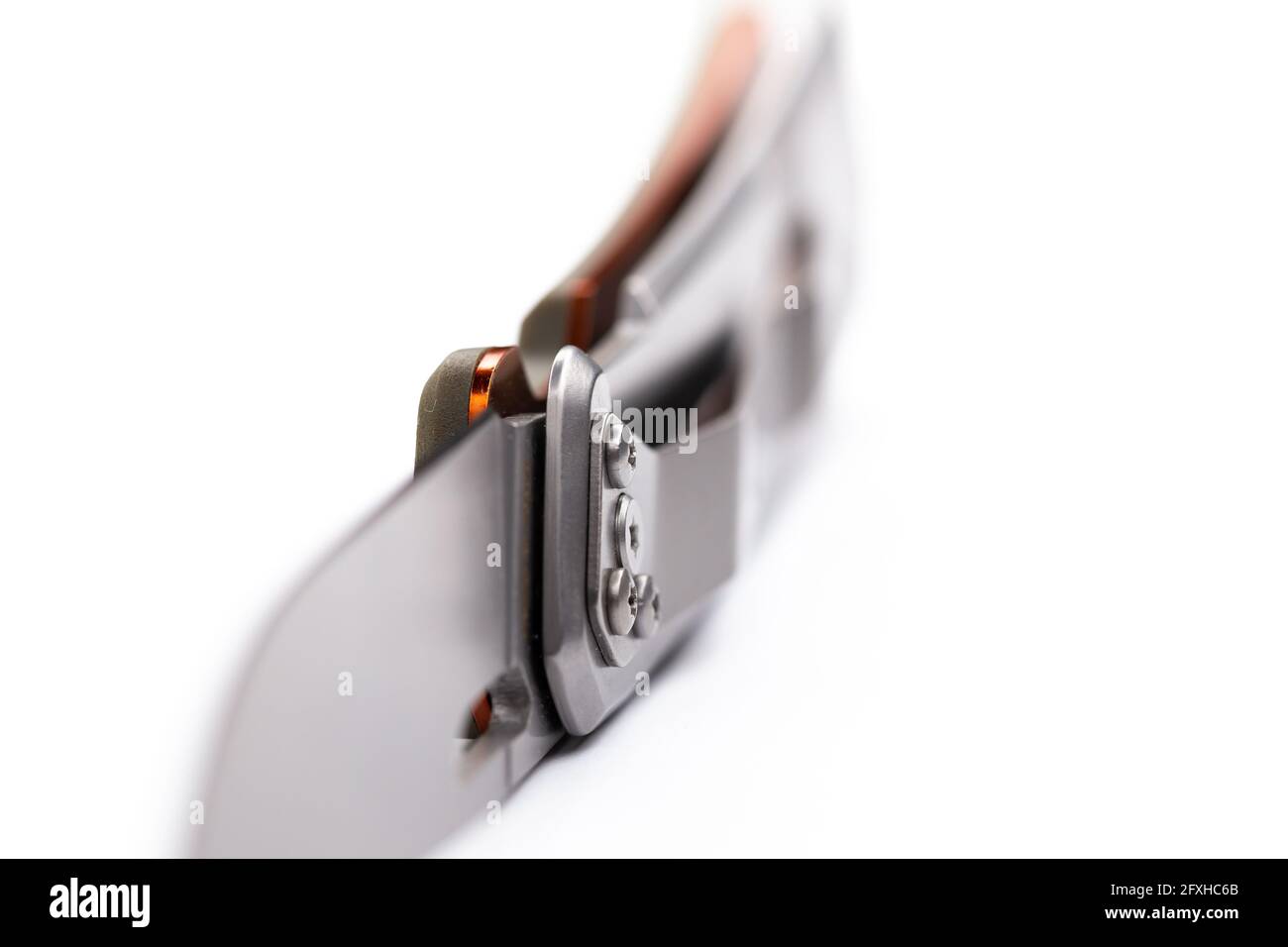 Ein kleines faltbares Jagdmesser isoliert auf dem weißen Hintergrund. Foto aufgenommen unter weichem Kunstlicht. Stockfoto