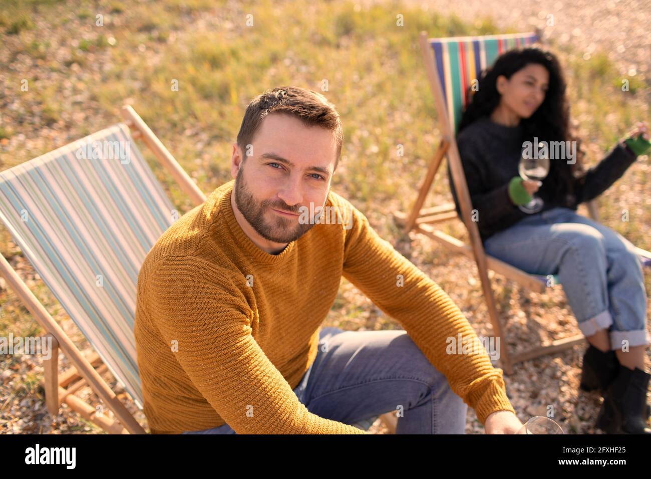 Portrait selbstbewusster Mann, der sich in einem Rasenstuhl von einer Freundin entspannt Stockfoto