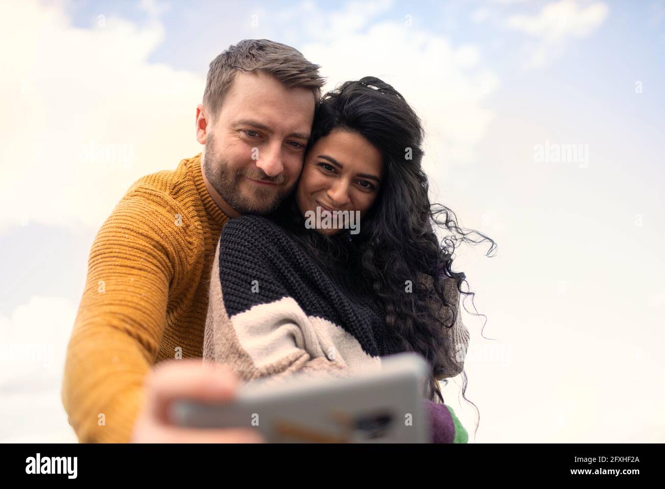 Glückliches, liebevolles Paar in Pullovern, die Selfie machen Stockfoto