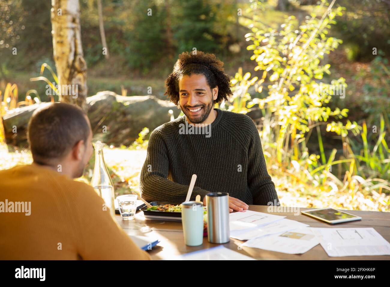 Geschäftsleute essen zu Mittag und diskutieren Papierkram am Parktisch Stockfoto