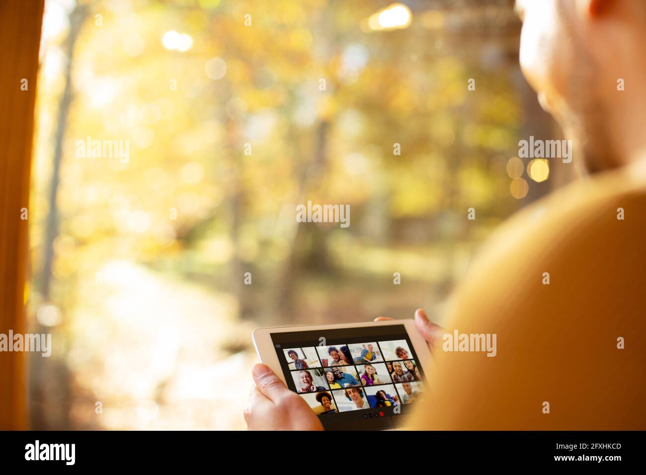 Mann Video chatten mit Freunden auf dem digitalen Tablet am sonnigen Fenster Stockfoto