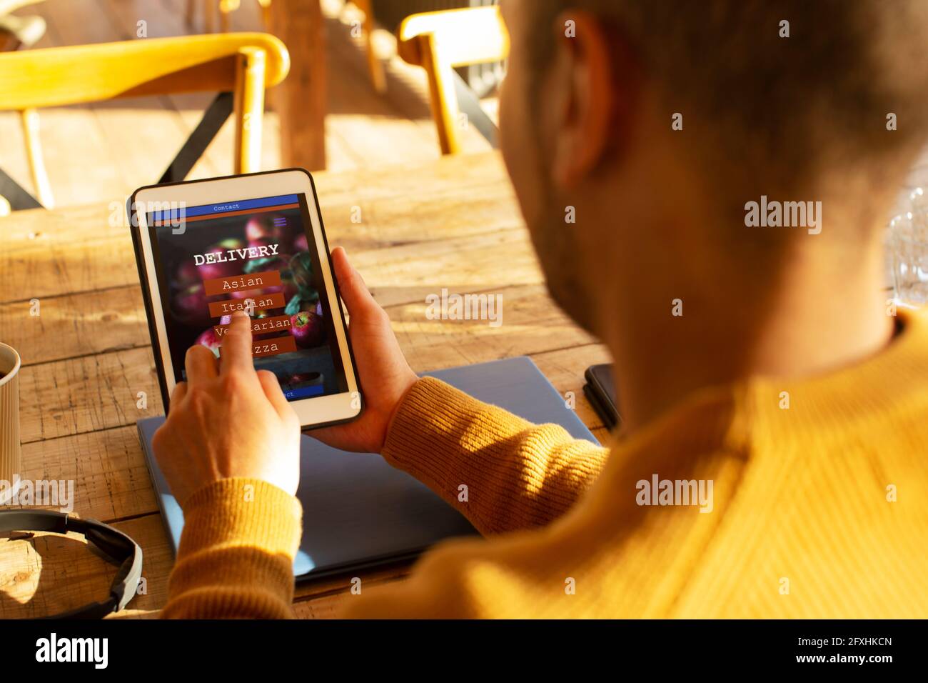 Mann mit digitalem Tablet, der Lebensmittel per App auf einem digitalen Tablet bestellt Stockfoto
