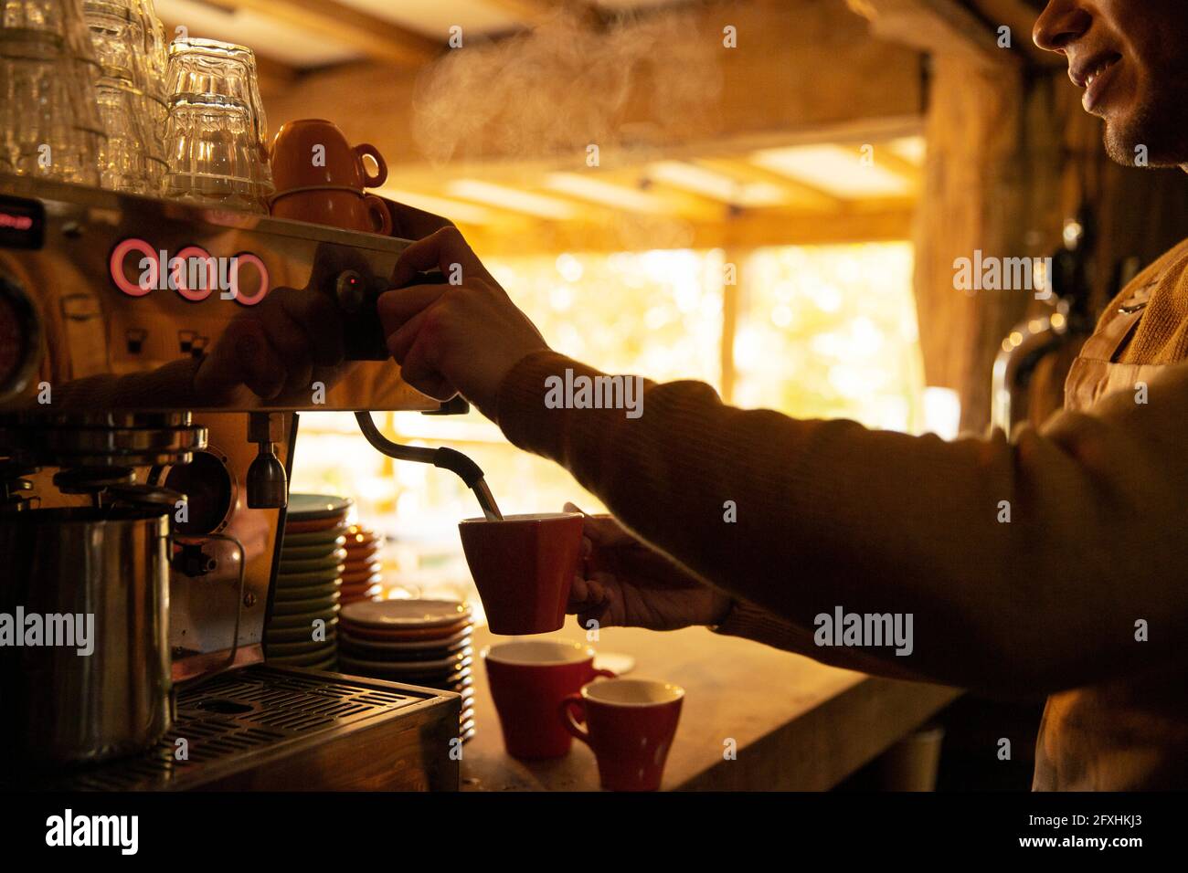 Barista bereitet Cappuccino an der Espressomaschine im Café zu Stockfoto
