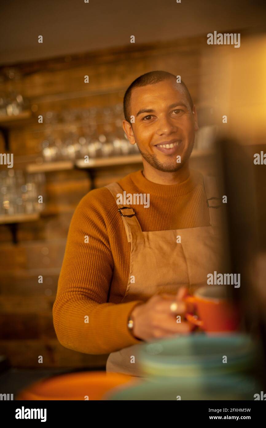 Portrait lächelnder, selbstbewusster Barista, der im Café Kaffee zubereitet Stockfoto