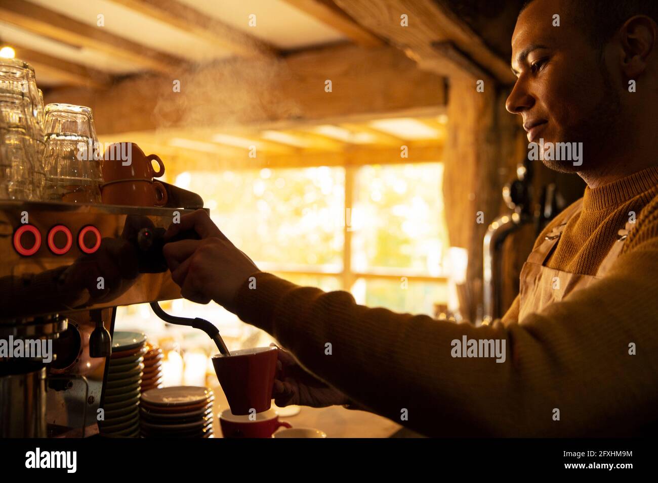 Barista bereitet Cappuccino an der Espressomaschine im Café zu Stockfoto