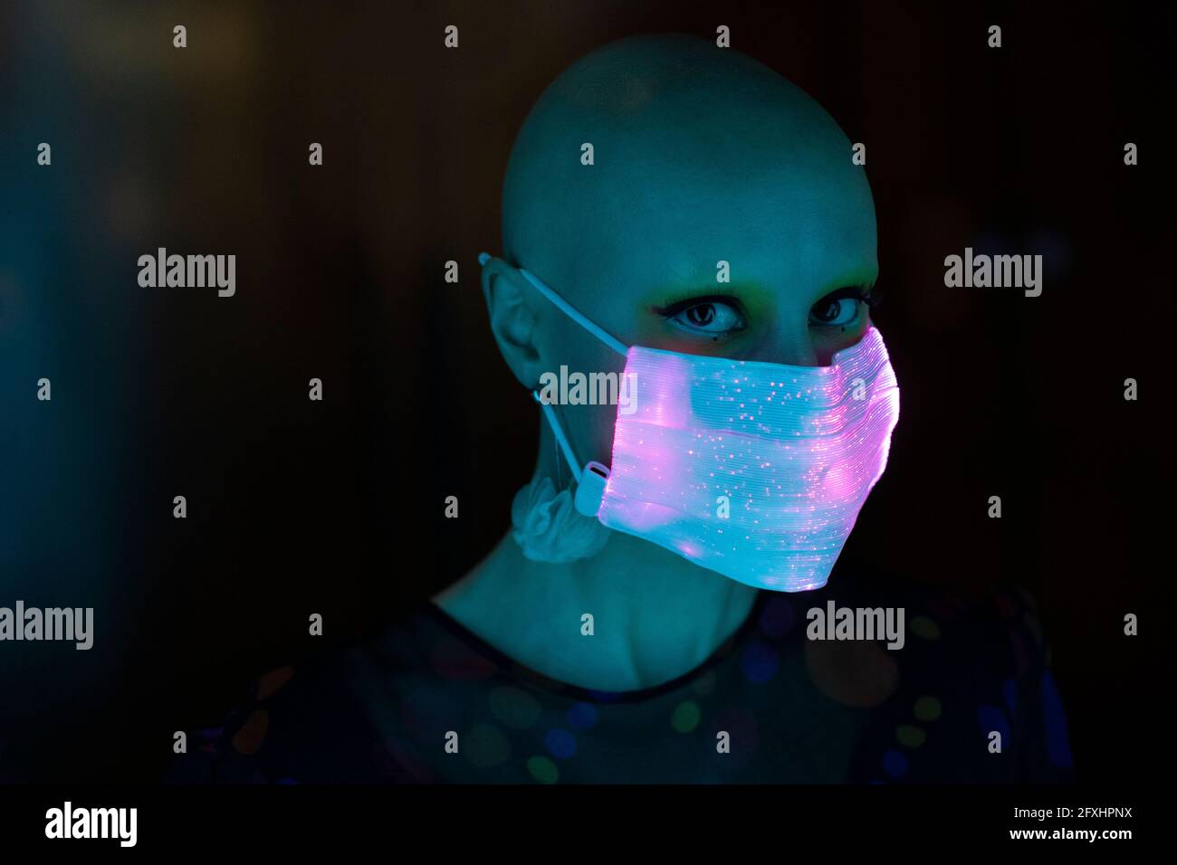 Portrait stilvolle Frau mit rasierten Kopf in schimmernden Maske Stockfoto