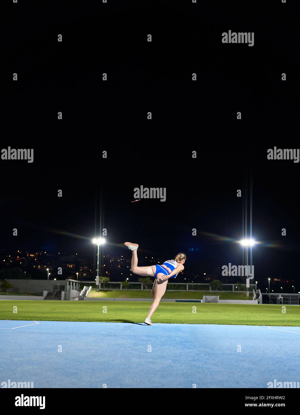 Weibliche Leichtathletik werfen Diskuswurf im Stadion in der Nacht Stockfoto