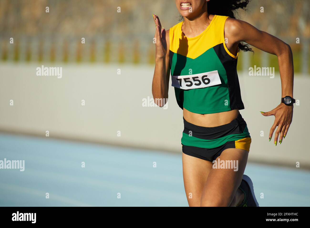 Entschlossene Leichtathletik-Sportlerin, die im Wettkampf läuft Stockfoto