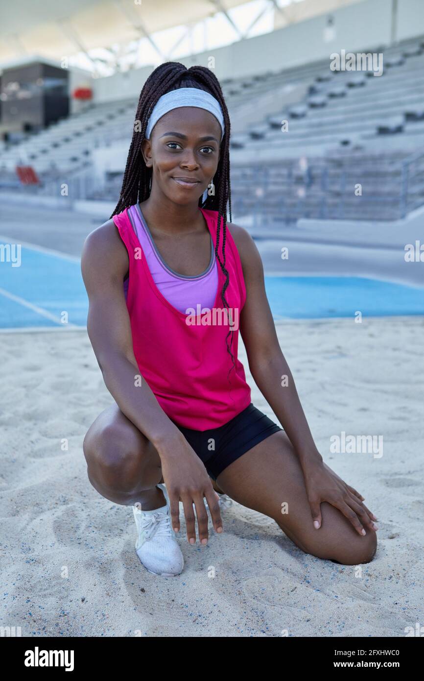 Portrait selbstbewusste weibliche Leichtathletik-Athletin im Weitsprung-Sand Stockfoto