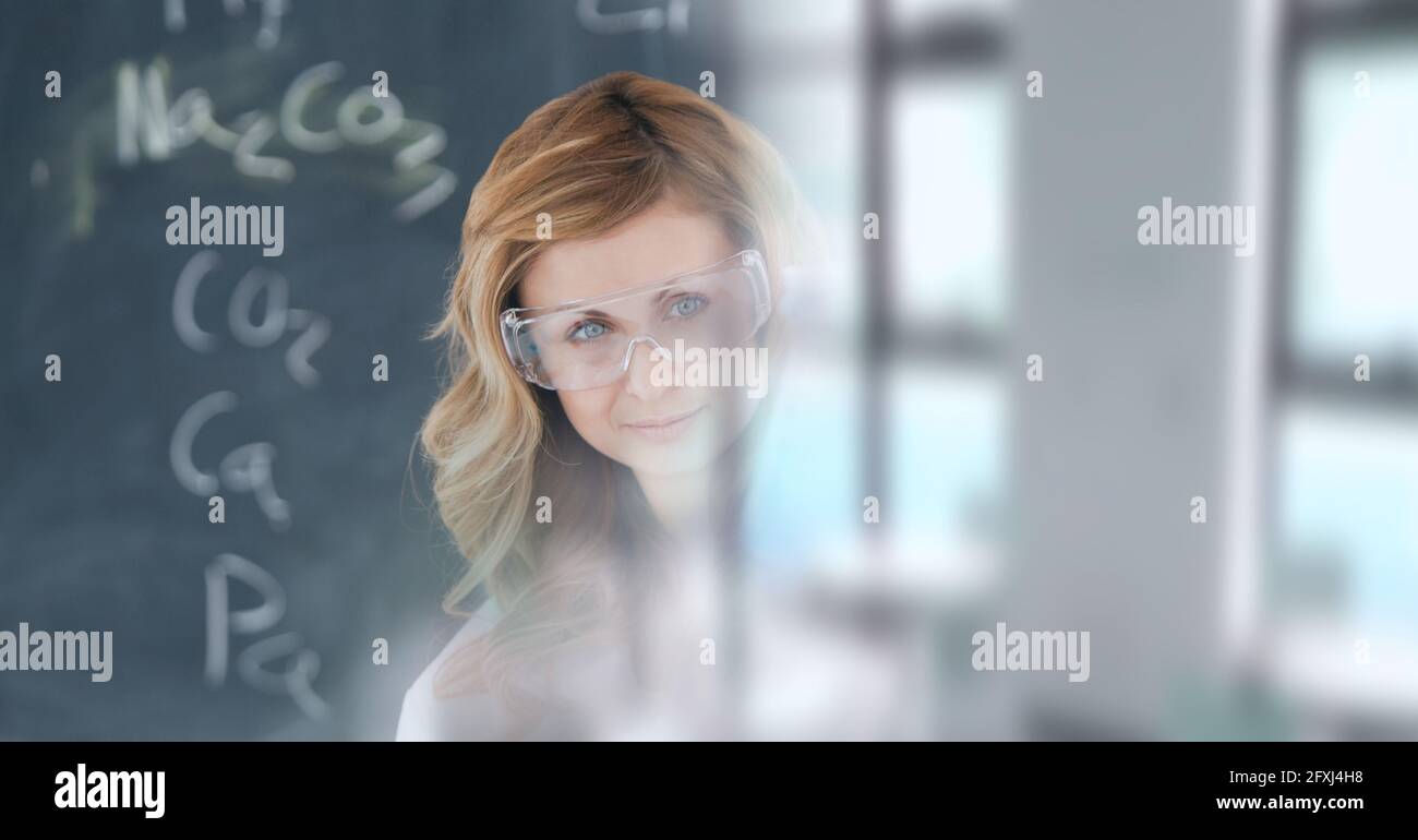 Zusammensetzung der lächelnden weiblichen kaukasischen Wissenschaftlerin in Schutzbrille arbeiten Im Labor Stockfoto