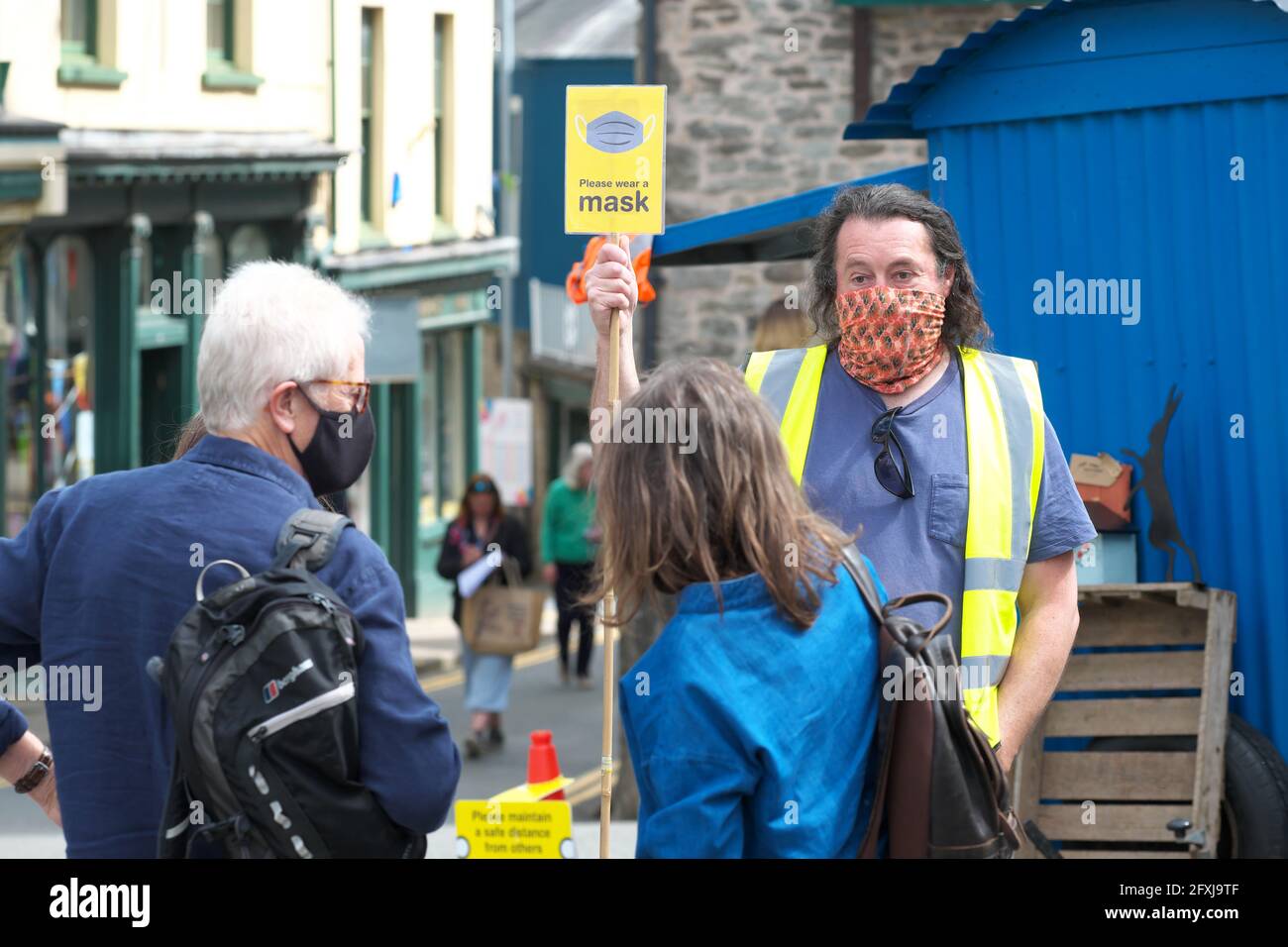 Covid marshall in Hay-on-Wye auf dem Marktplatz ermutigte die Besucher, eine Gesichtsmaske um die Imbissstände zu tragen. Stockfoto