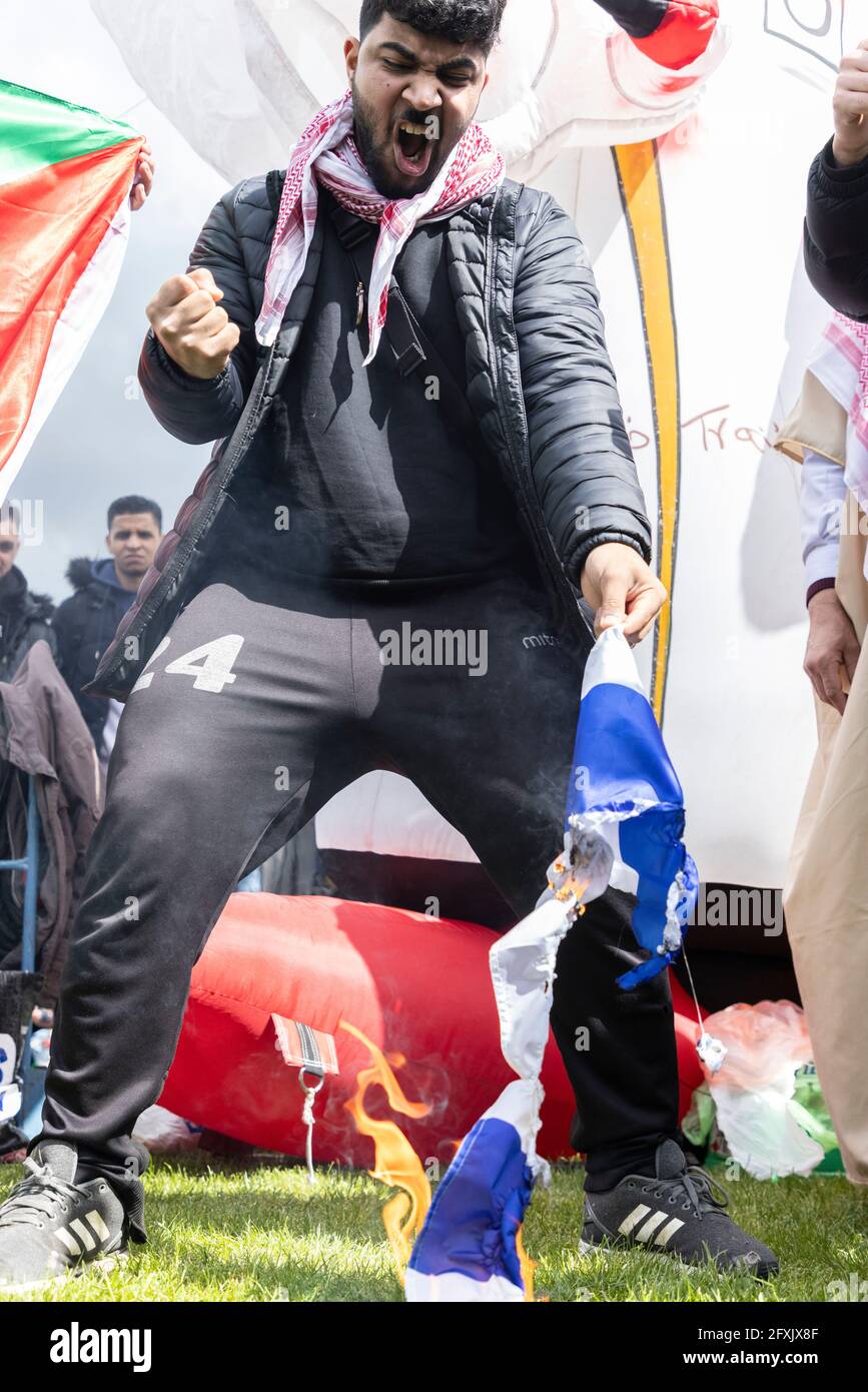 Ein wütender Protestler steht über brennender israelischer Flagge, Protest gegen Free Palestine, Hyde Park, London, 22. Mai 2021 Stockfoto