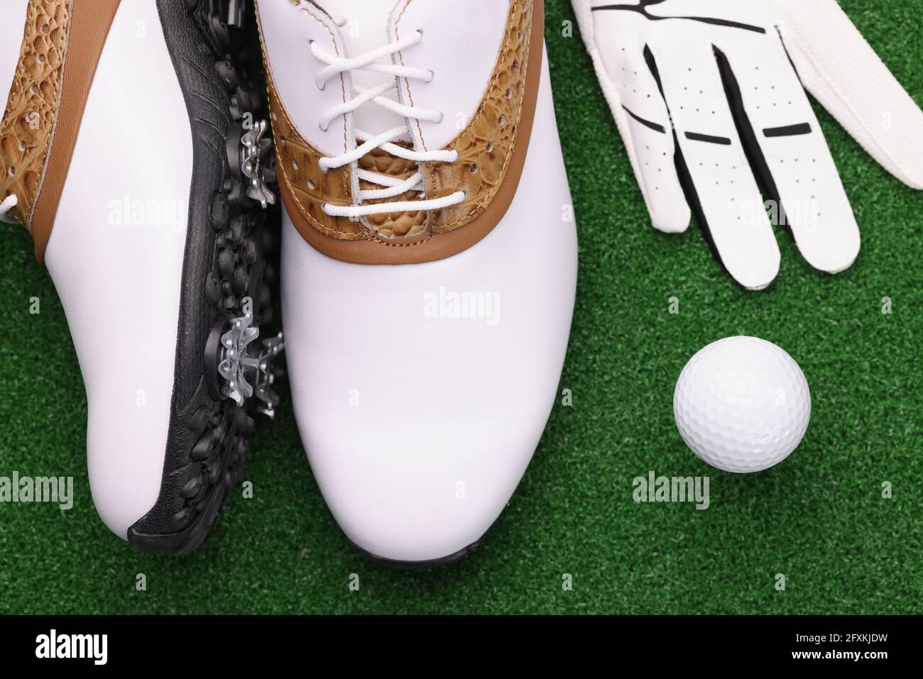 Golfschuhe Ball und weiße Handschuhe liegen auf grünem Rasen Stockfoto