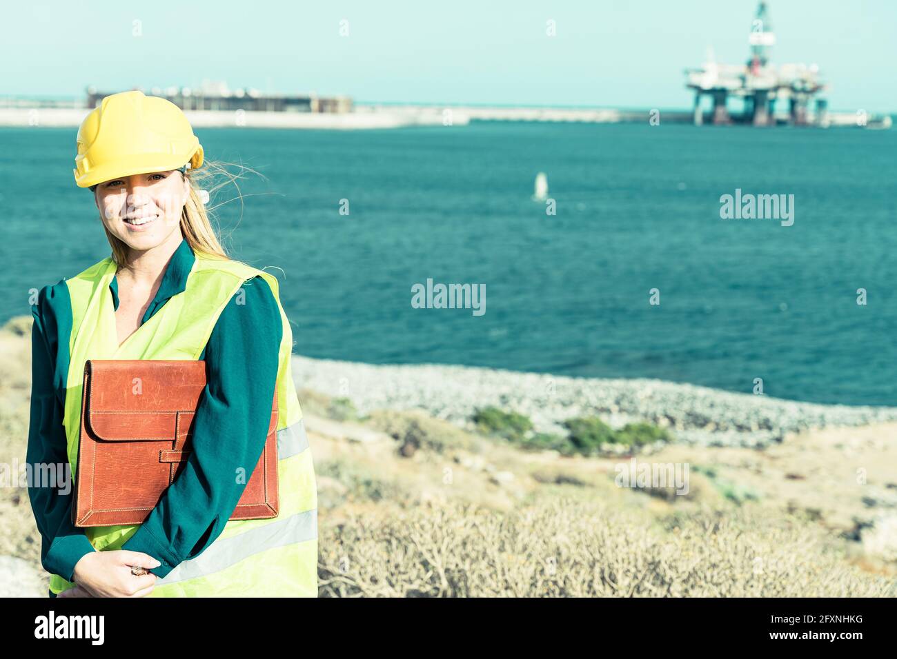 Ein Porträt einer Ingenieurin aus der Industrie, die in einem Industriehafen steht. Industrie und Berufskonzept. Stockfoto