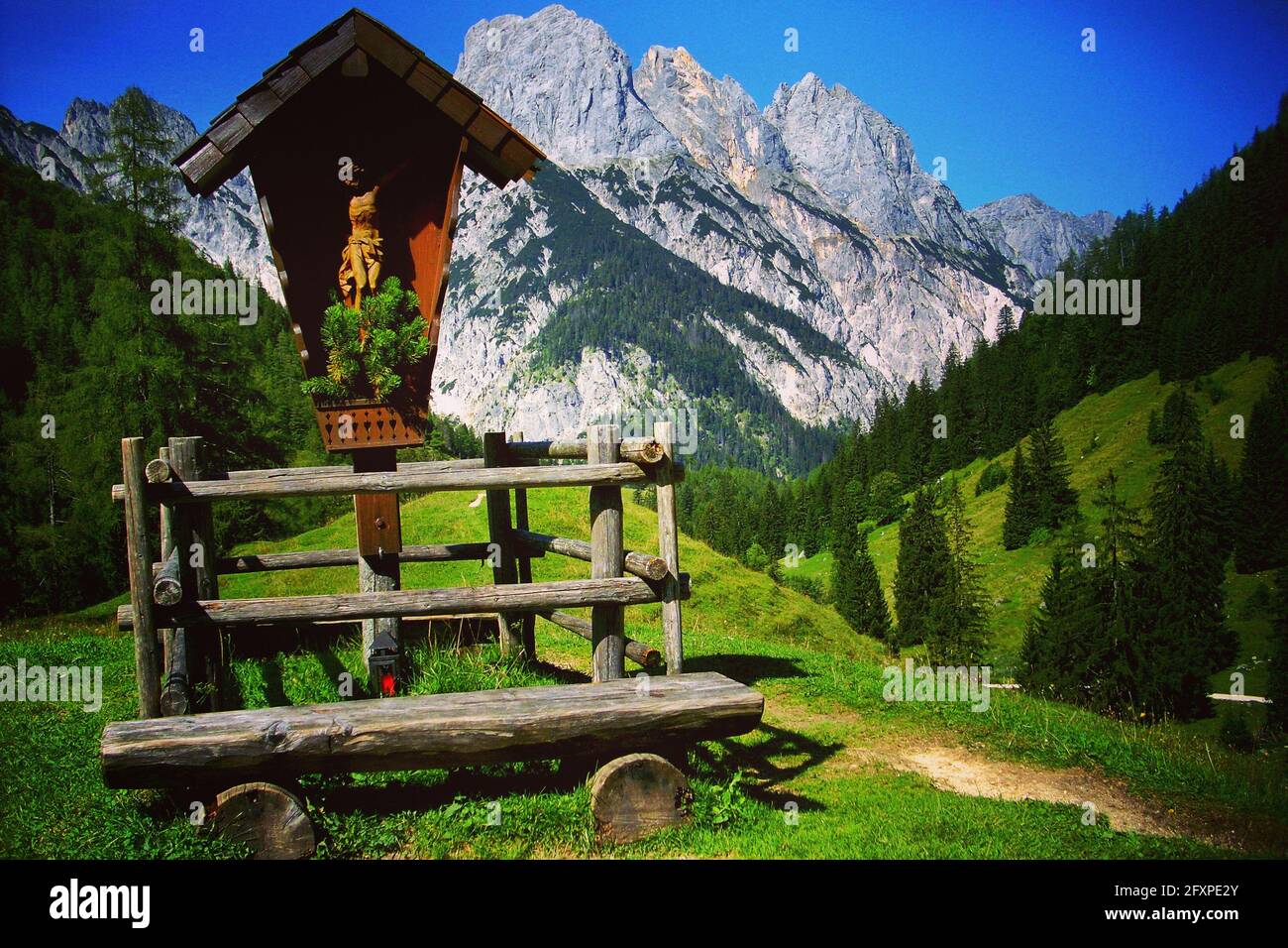 Bayerische Berglandschaft im Nationalpark Berchtesgaden, Deutschland, Europa. Wegekreuz mit Bank hoch in den Bayerischen Alpen, Bayern. Stockfoto