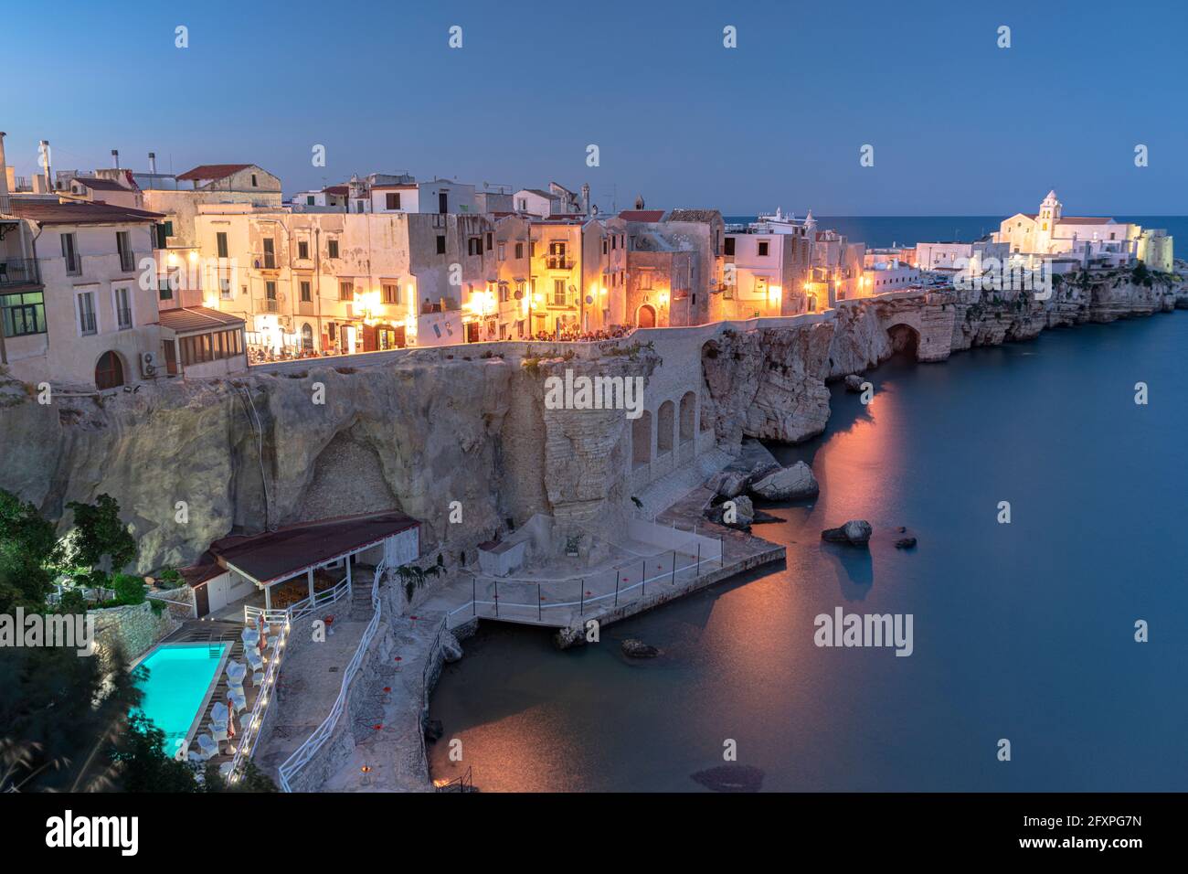 Beleuchteter Pool von Luxus-Resort am Meer bei Dämmerung in Vieste Altstadt, Foggia Provinz, Gargano, Apulien, Italien, Europa Stockfoto
