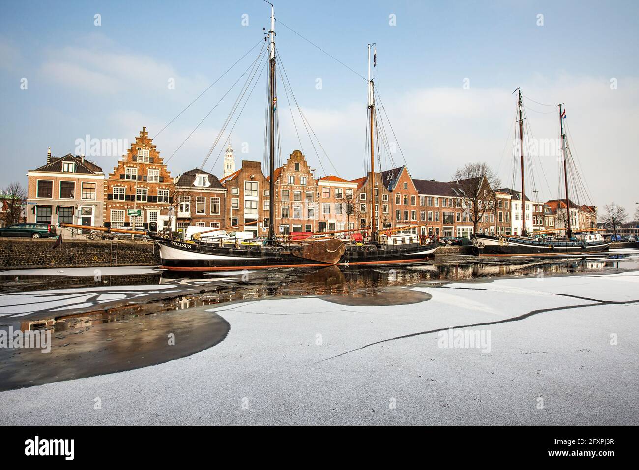 Hausfassaden und Boote, die im gefrorenen Kanal des Spaarne-Flusses, Haarlem, Amsterdam, Nord-Holland, Niederlande, Europa Stockfoto