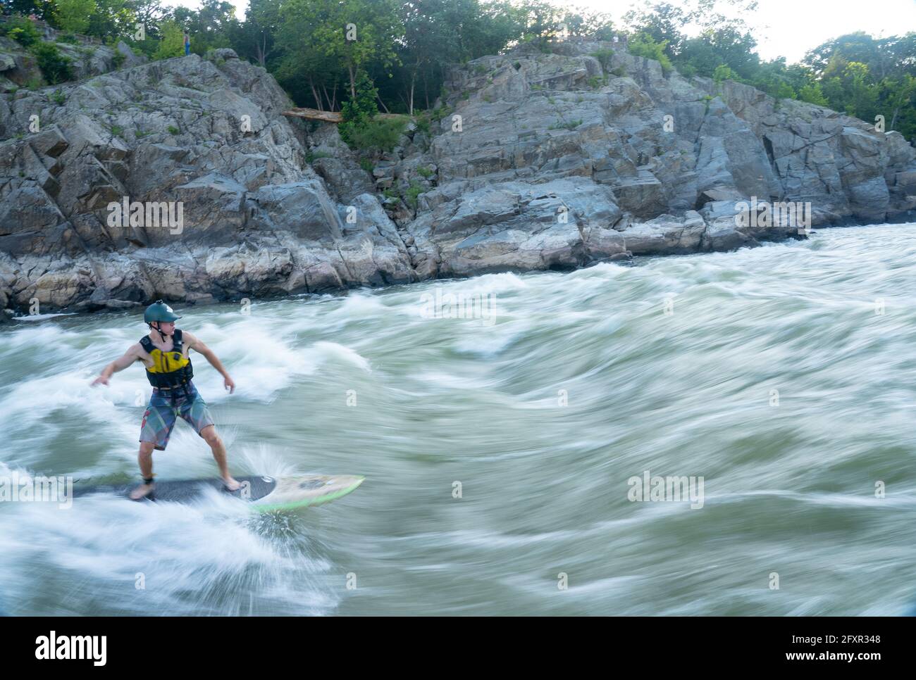 Ian Brown steht Up Paddle surft anspruchsvolles Wildwasser unter den Great Falls des Potomac River, der Grenze zwischen Maryland und Virginia, USA, Nordamerika Stockfoto
