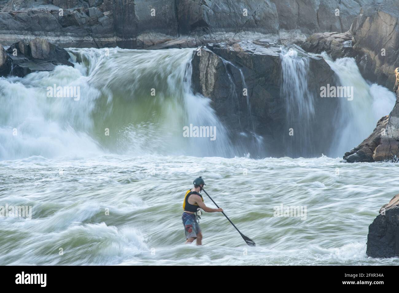 Ian Brown steht Up Paddle surft anspruchsvolles Wildwasser unter den Great Falls des Potomac River, der Grenze zwischen Maryland und Virginia, USA, Nordamerika Stockfoto