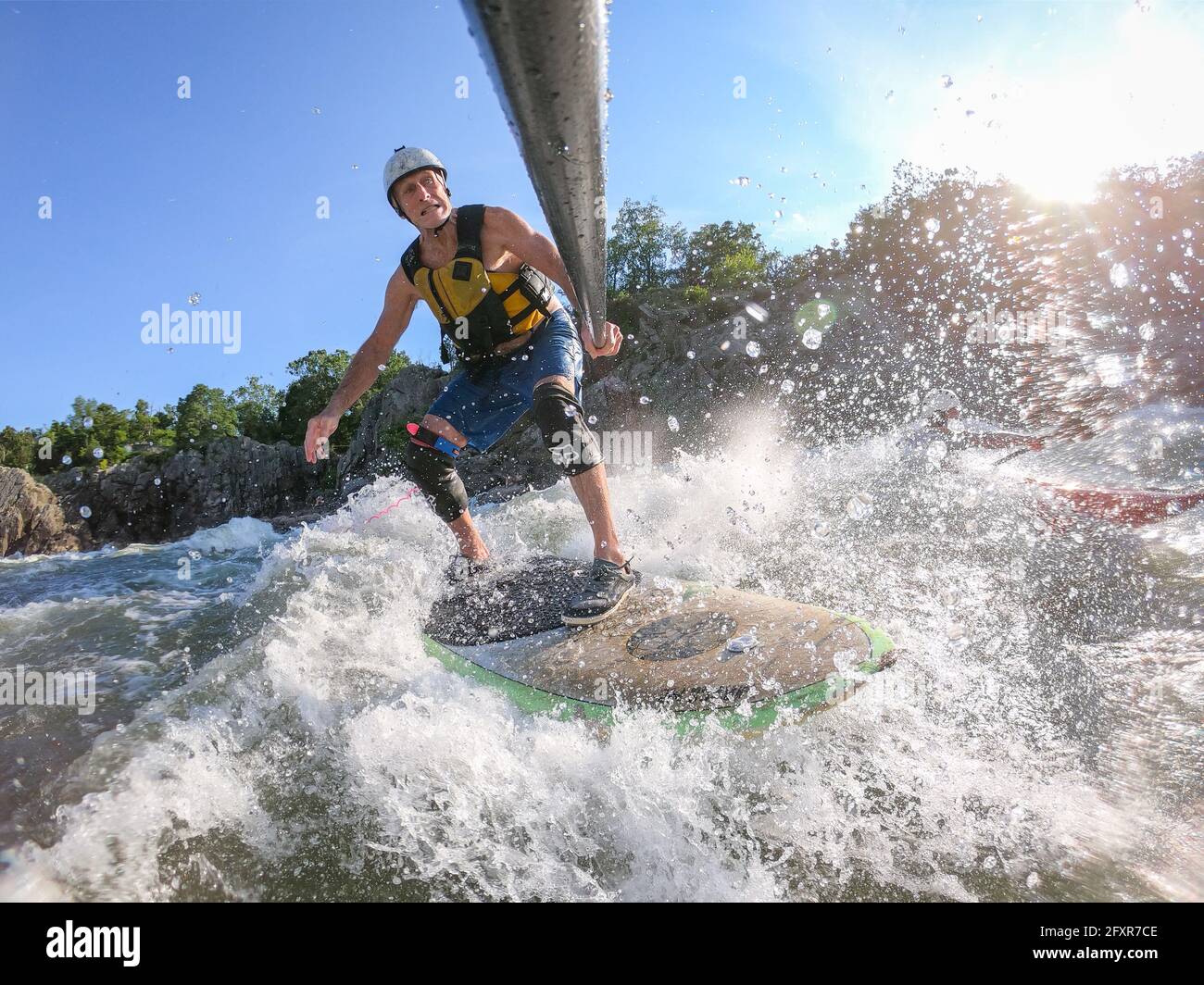 Der Fotograf Skip Brown steht auf dem Paddle unter den Great Falls des Potomac River, an der Grenze zwischen Virginia und Maryland, USA, in anspruchsvollem Wildwasser Stockfoto