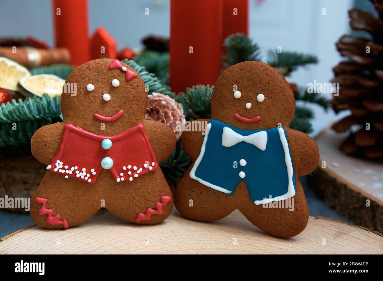 Weihnachts-Lebkuchen in Form von fröhlichen Männern. Weihnachtsbaum im Hintergrund. Stockfoto