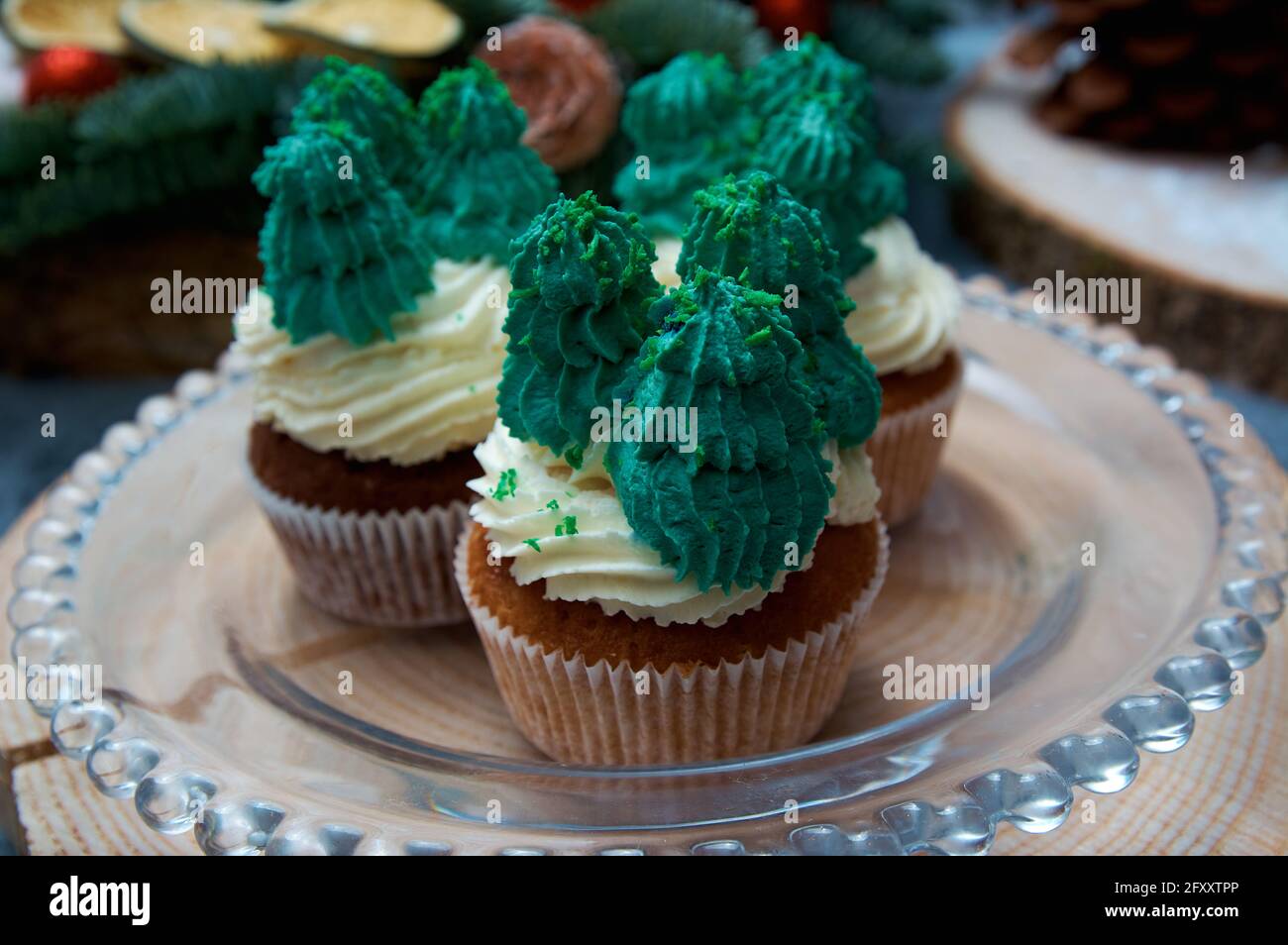 Ferien-Muffins mit Wintermotiven. Weiße und grüne Cremecreme. Weihnachtskuchen. Stockfoto