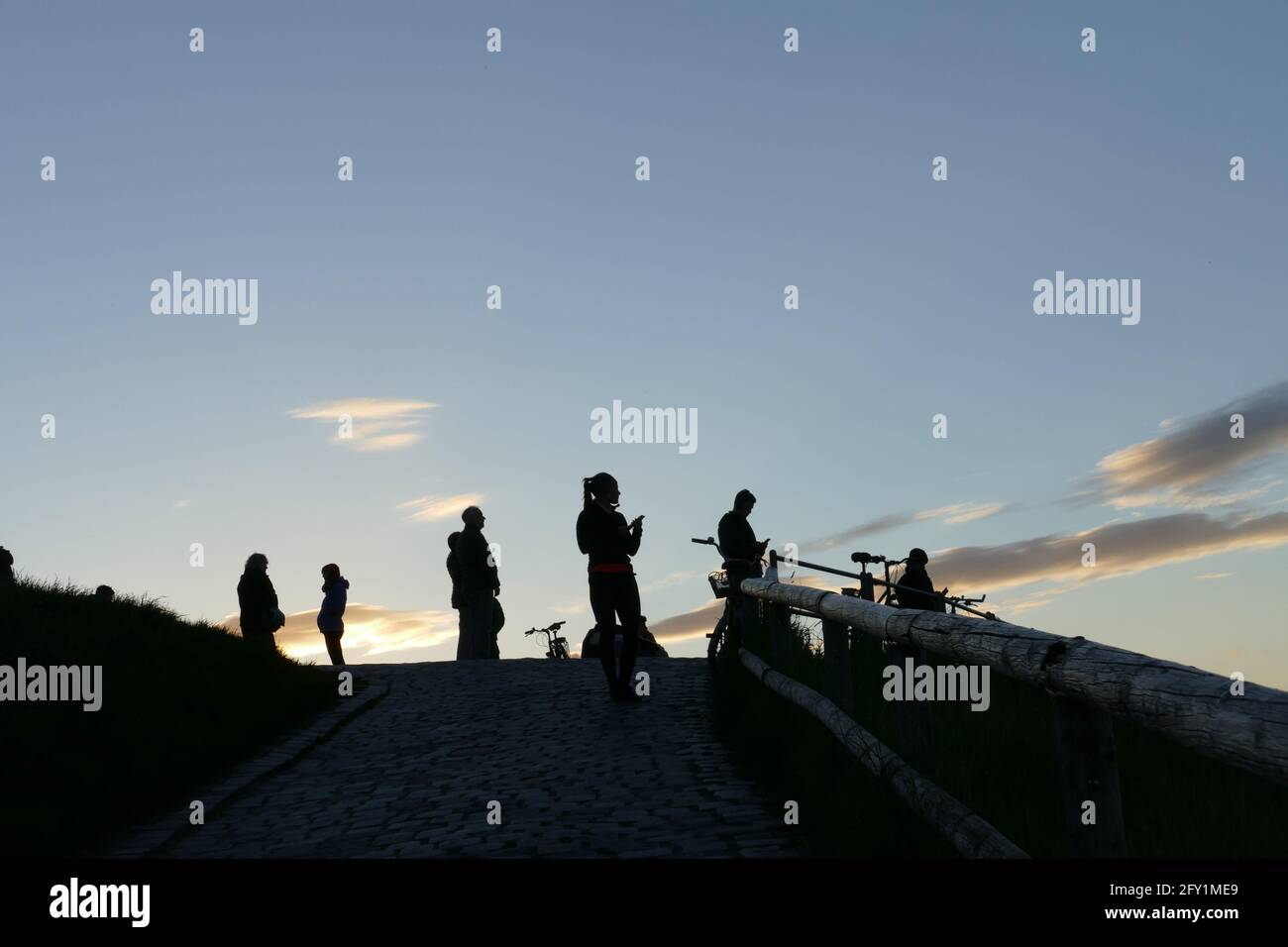 Silhouetten von Menschen, die ihre Freizeit oder ihre Freizeit auf einem städtischen Berg verbringen. Stockfoto