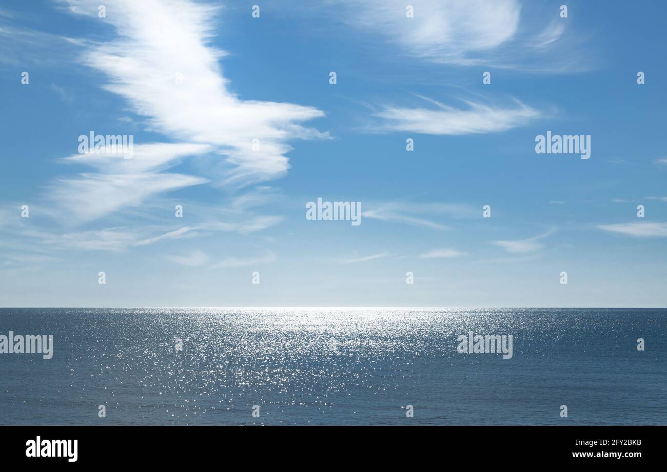 Wolkenbildung über dem Meer mit Sonnenreflexionen. Stockfoto