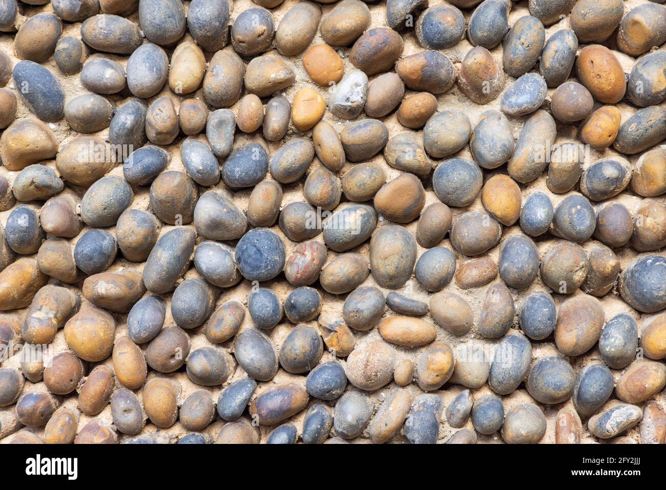 Nahaufnahme einer Steinmauer aus Strandkieseln. Hintergrundtextur. Stockfoto