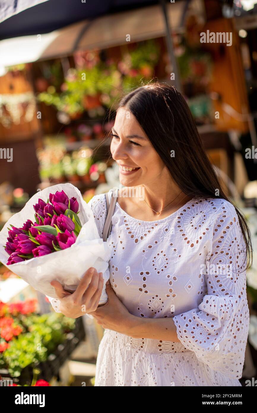 Hübsche junge Frau, die Blumen auf dem Blumenmarkt kauft Stockfoto