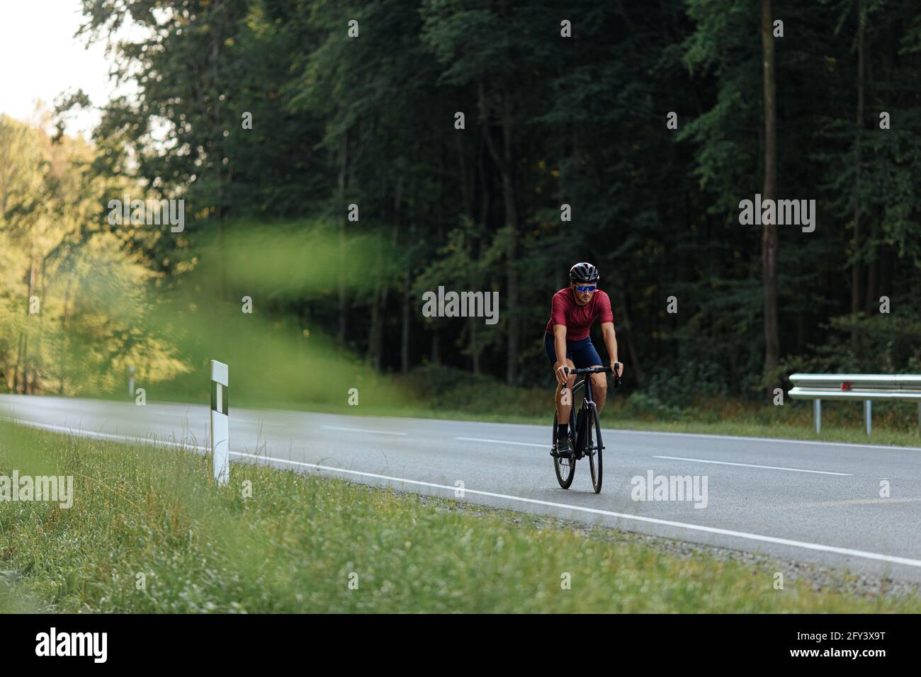 Starker Kerl, der Fahrrad im Schutzhelm draußen reitet Stockfoto