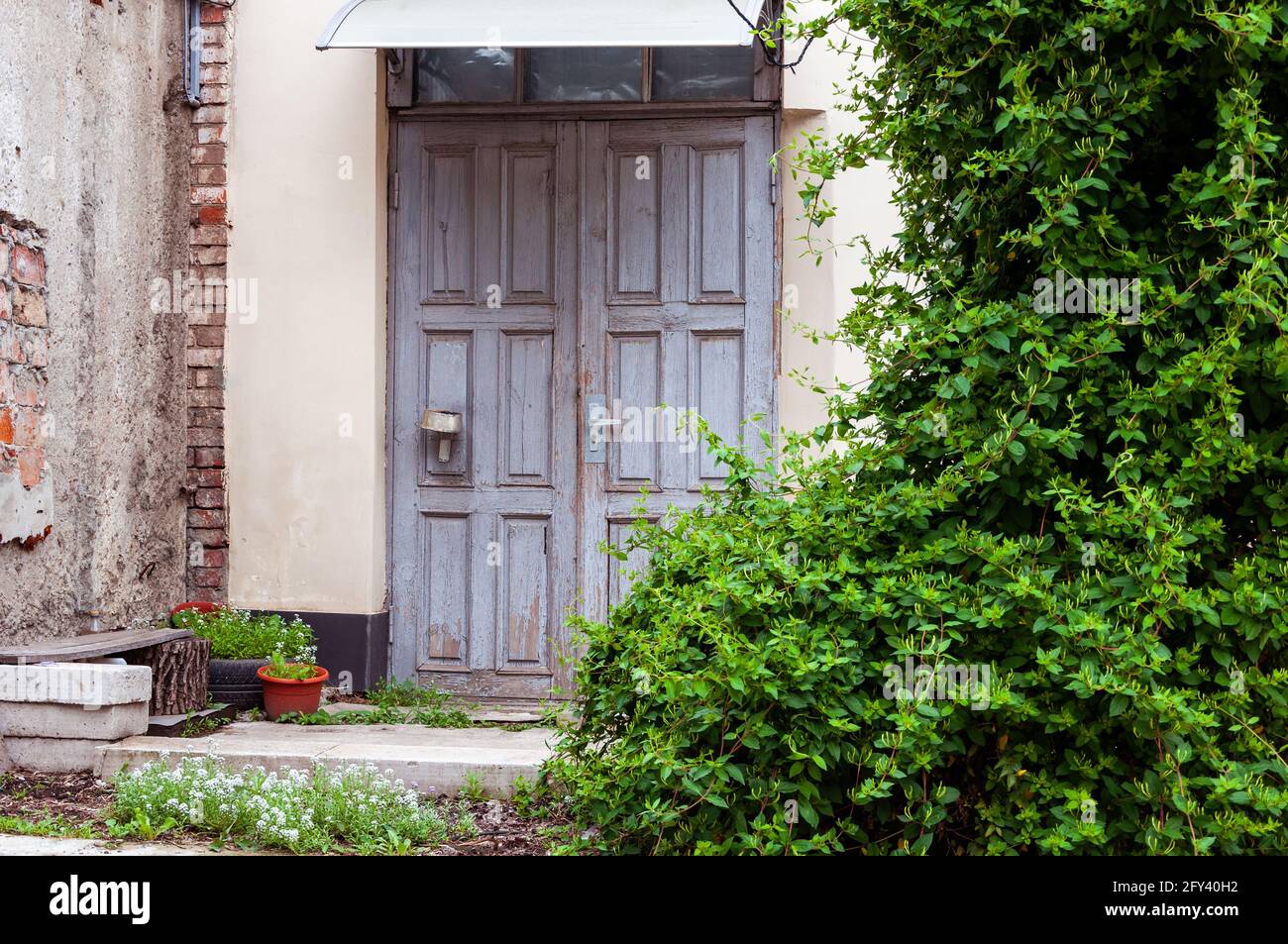 Hinterhof Des Alten Hauses. Blumentöpfe Vor Dem Haus. Landschaftlich gestalteter Hinterhof des alten Hauses. Altes Steinhaus im Dorf Stockfoto