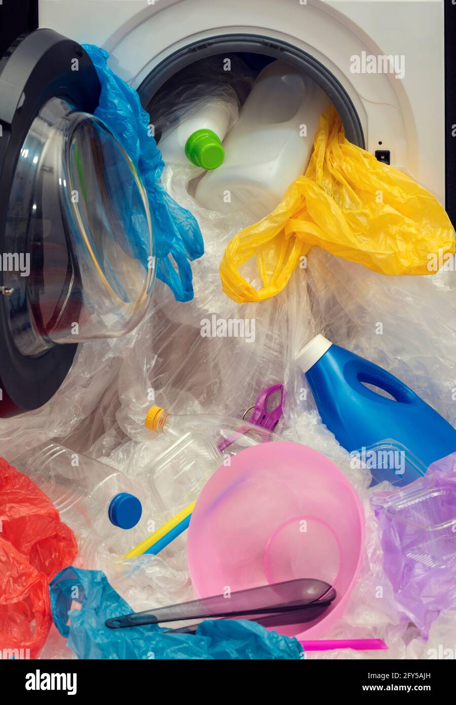 Waschmaschine voller Plastik. Stoppen Sie die Verschmutzung des Ozeans. Zero Waste und nachhaltiges Lifestyle-Konzept. Stockfoto