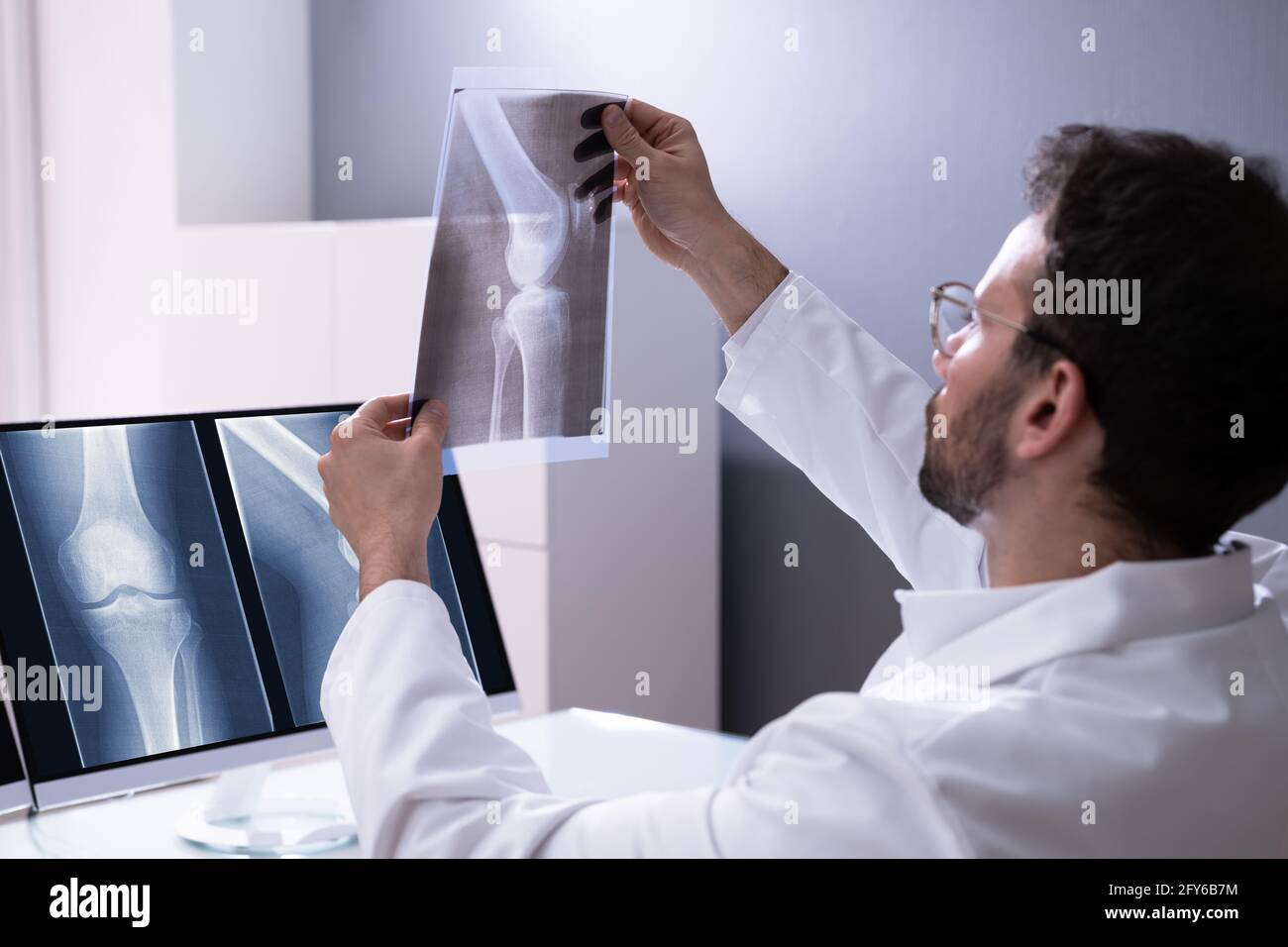 Arzt Screening Knie Knochen X Ray am Computer Stockfoto