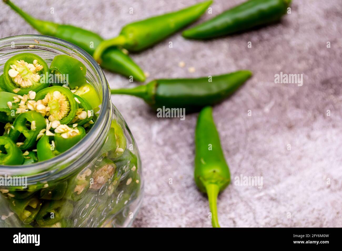 Peperoni und Jalapeno-Paprika platziert und mariniert in einem Glas Stockfoto