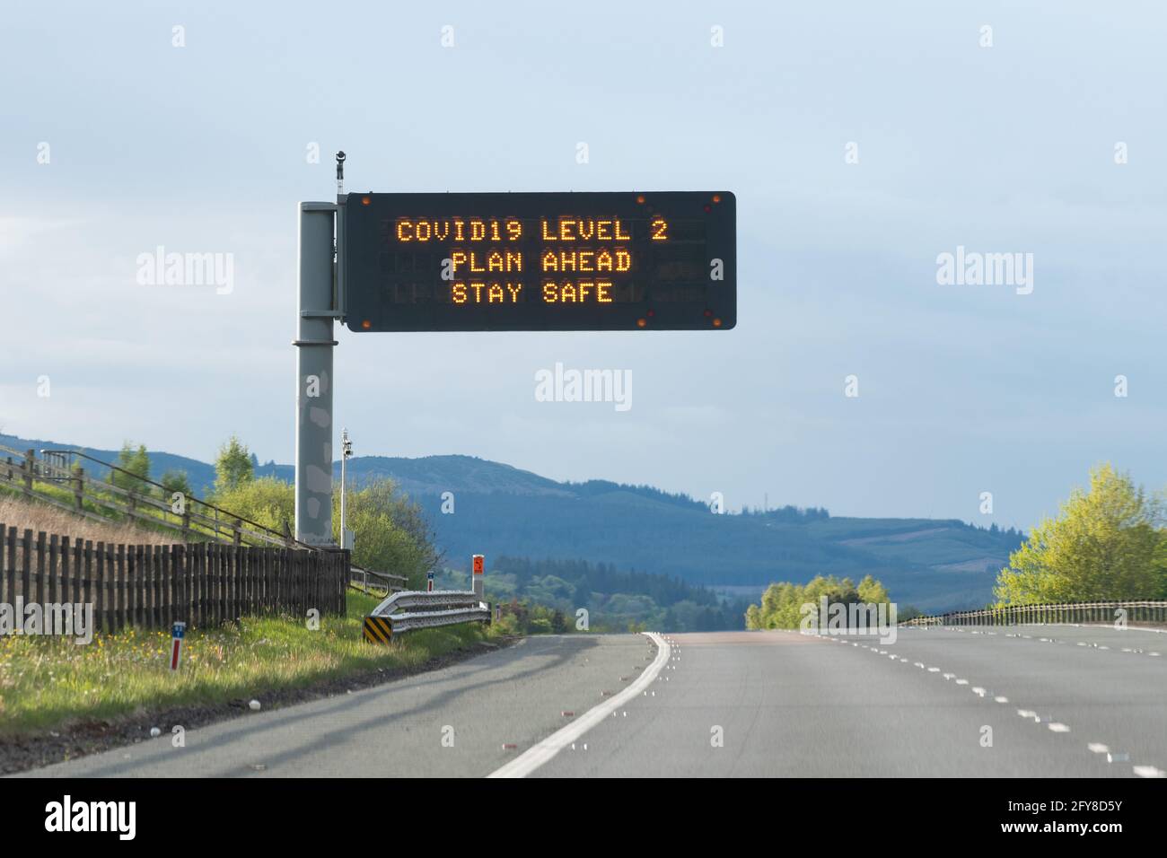 Covid 19 Level 2 Einschränkungen Autobahnschild - Schottland, Vereinigtes Königreich Stockfoto