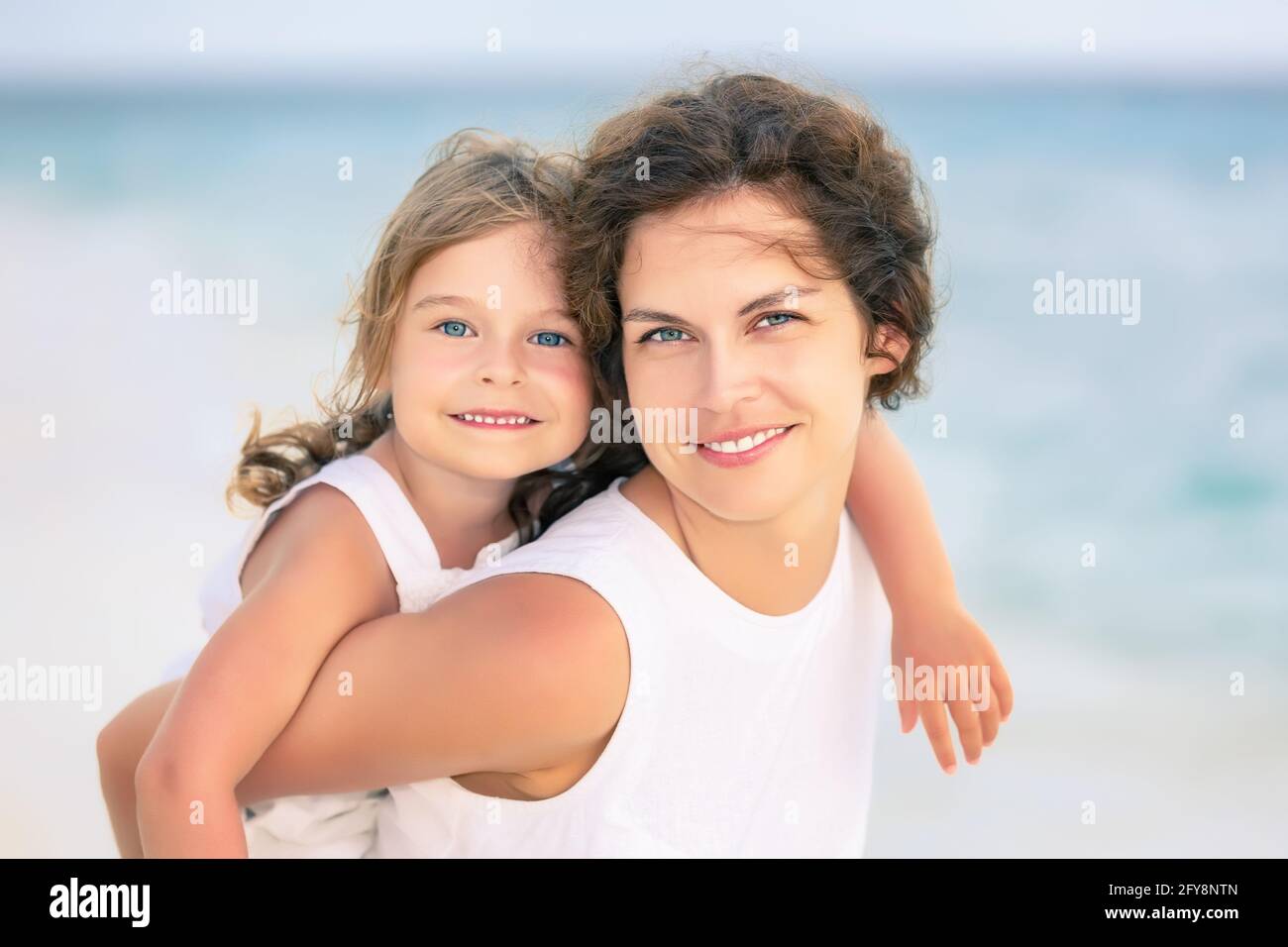 Portrait von glücklicher Mutter und kleiner Tochter am Meeresstrand auf den Malediven im Sommerurlaub. Familie am Strand Konzept. Stockfoto