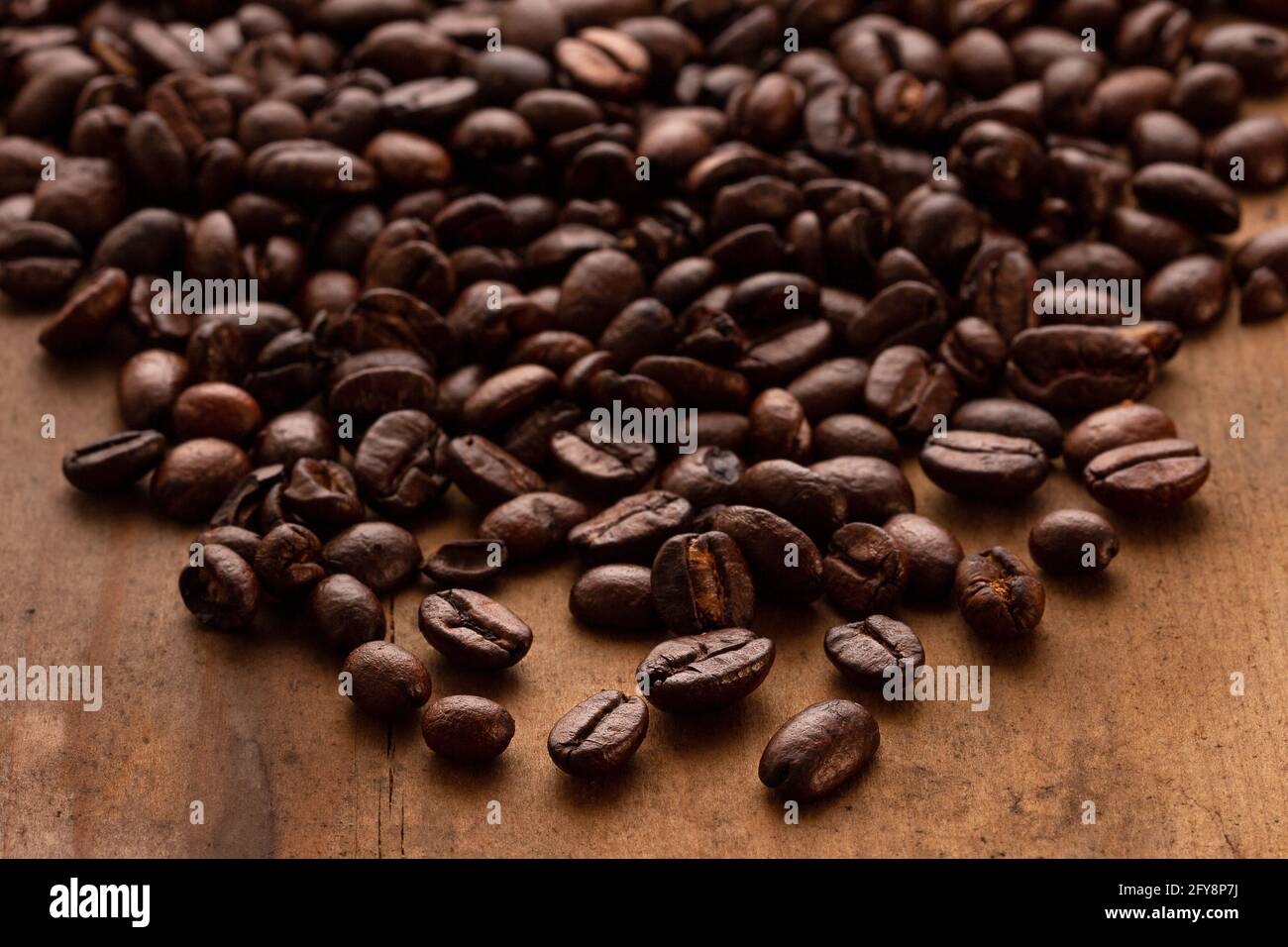 Geröstete Kaffeebohnen verschüttet auf einen Tisch Stockfoto