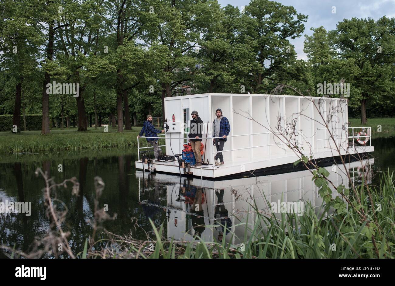 Hannover, Deutschland. Mai 2021. Während der KunstFestSpiele Herrenhausen segeln Mitglieder der Künstlergruppe YRD.Works im Großen Garten über das Graft. Speziell für die Kunstfestspiele wurde ein etwa neun mal drei Meter langes Floß gebaut, während die Gäste während der rund 40-minütigen Fahrt eine Soundcollage mit einem Audioguide hören. Kredit: Eman Helal/dpa/Alamy Live Nachrichten Stockfoto