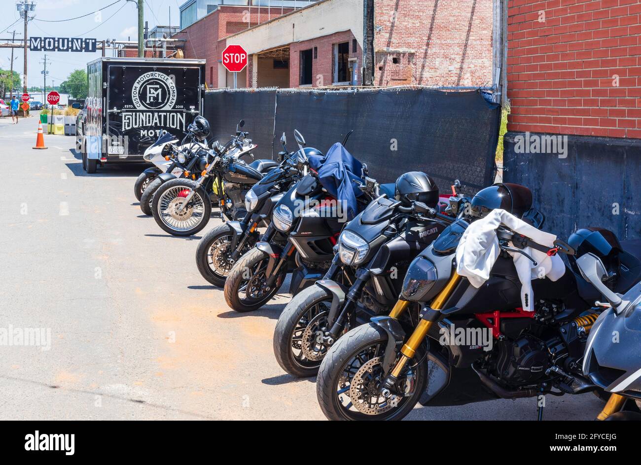 CHARLOTTE, NC, USA-23. MAI 2021: Camp North End. Eine Reihe von Motorrädern und ein Anhänger Werbung Foundation Moto, ein Custom-Motorrad-Unternehmen. Stockfoto