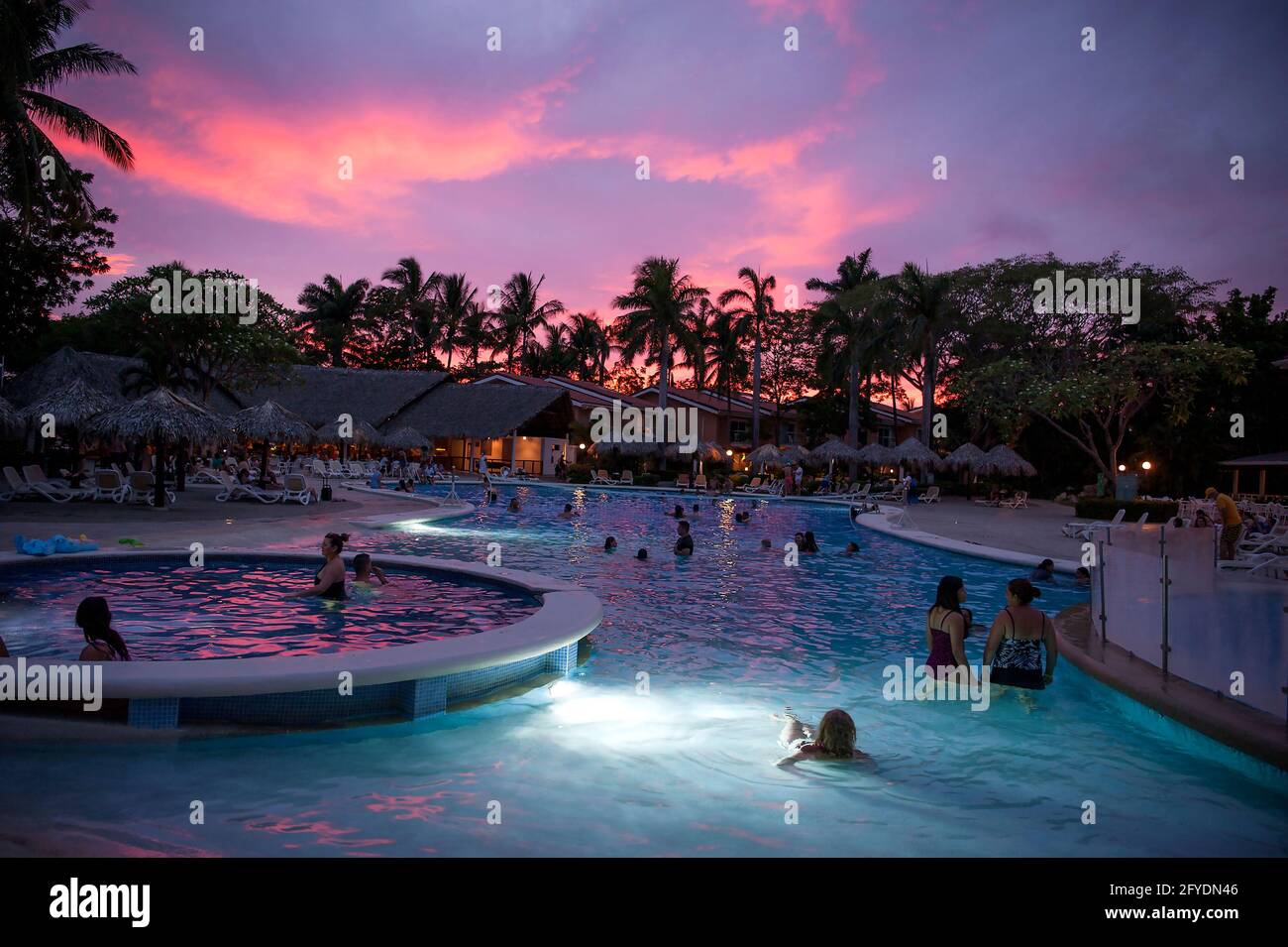 Menschen, die den Sonnenuntergang von einem Pool in Tamarindo, Costa Rica, Mittelamerika aus beobachten Stockfoto