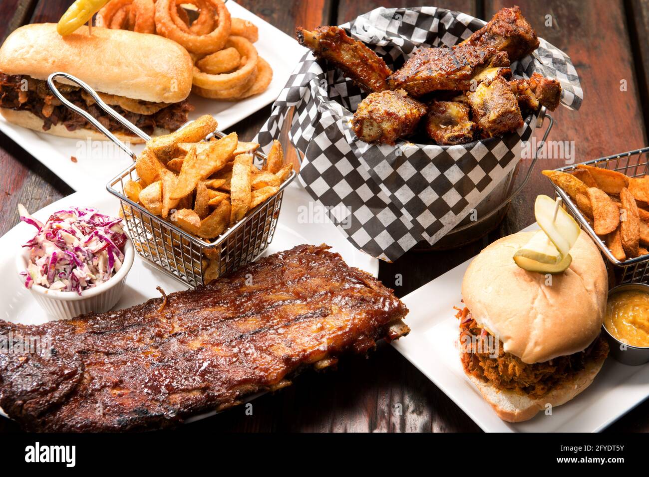 Barbecue Restaurant Essensauswahl. Gegrillte Schweineribs, Rinderrippen, Pulled-Pork-Sandwich und Rindfleisch-Dip mit hausgemachten pommes frites. Stockfoto